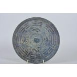 A Chinese bronze mirror with embossed decoration of mythical beasts, 8¼" diameter