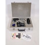 A Nikon F-401S 35mm SLR camera with Sigma UC zoom lens and accessories, in an aluminium flight case,