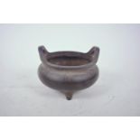 A Chinese bronze censer on tripod feet with two phoenix eye handles, impressed mark to base, 5"