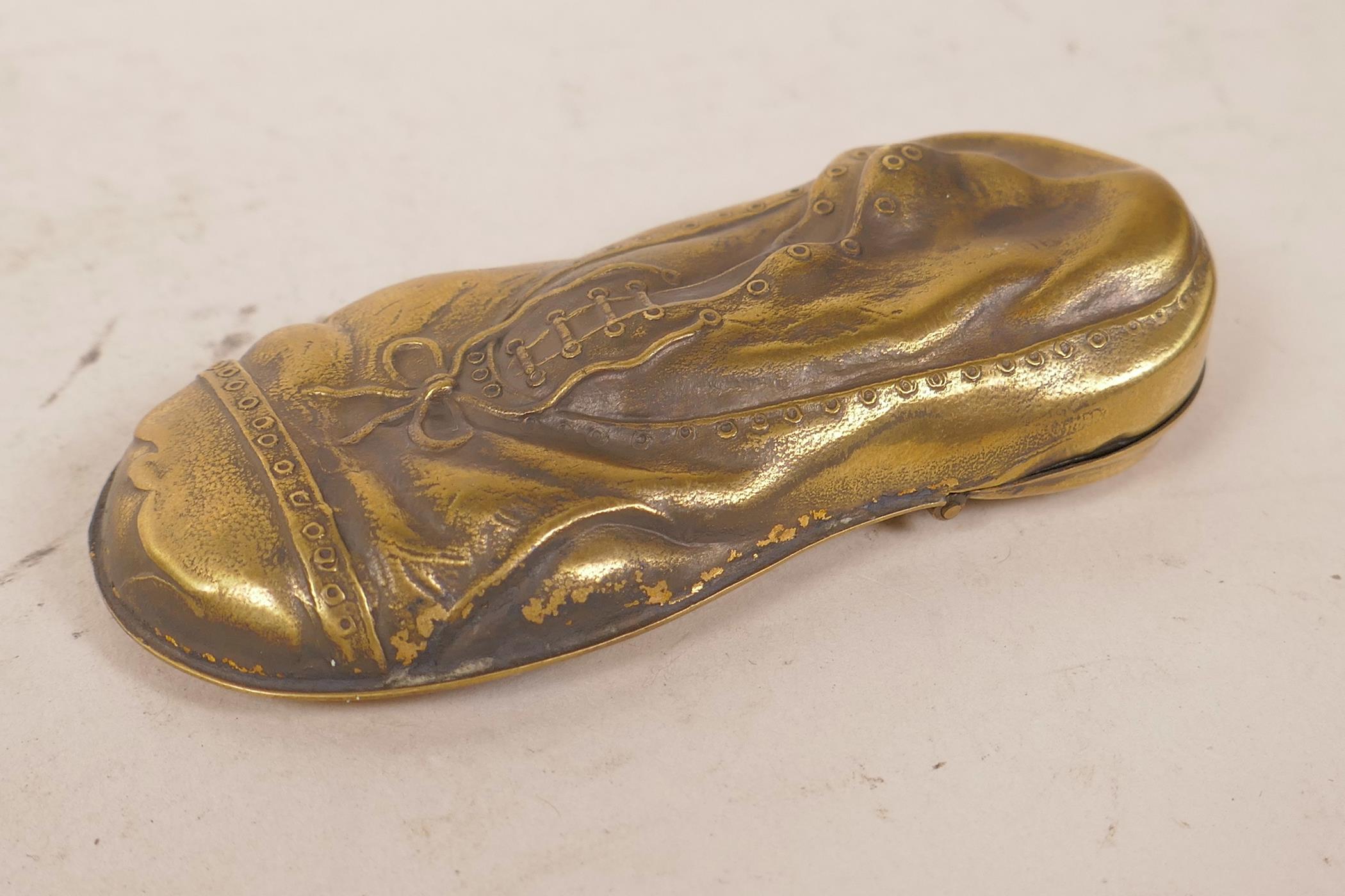 A novelty brass vesta case in the form of a lady's shoe within a shoe, 3" long