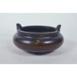 A Chinese bronze censer with two handles and tripod feet, impressed 4 character mark to base, 4"