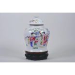 A Chinese Republic ginger jar and cover decorated with women and children in a garden, on a carved