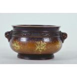 A Chinese bronze censer with two mask handles and gilt patina, impressed six character mark to base,