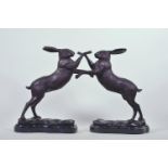 A pair of bronzed metal figures of boxing hares, 11½" high