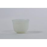 A small Mughal white jade cup with carved petal decoration, 1" diameter