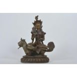 A Chinese patinated bronze figure of Buddha seated on a mythical beast, 10" high