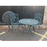 A painted metal garden table and two matching chairs and a tilt top garden table