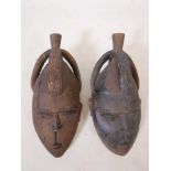 A pair of African wooden masks, with incised decoration, 17" long x 8" wide x 6" high