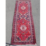 A Persian heavy pile red ground village runner, 44" x 124"