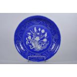 A large Chinese blue and white pottery charger with raised and incised floral decoration, incised