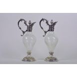 A pair of silver plate and whirled glass decanters with cast serpent handles and pineapple