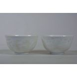 A pair of Chinese white ground porcelain tea bowls with white enamel dragon and kylin decoration,