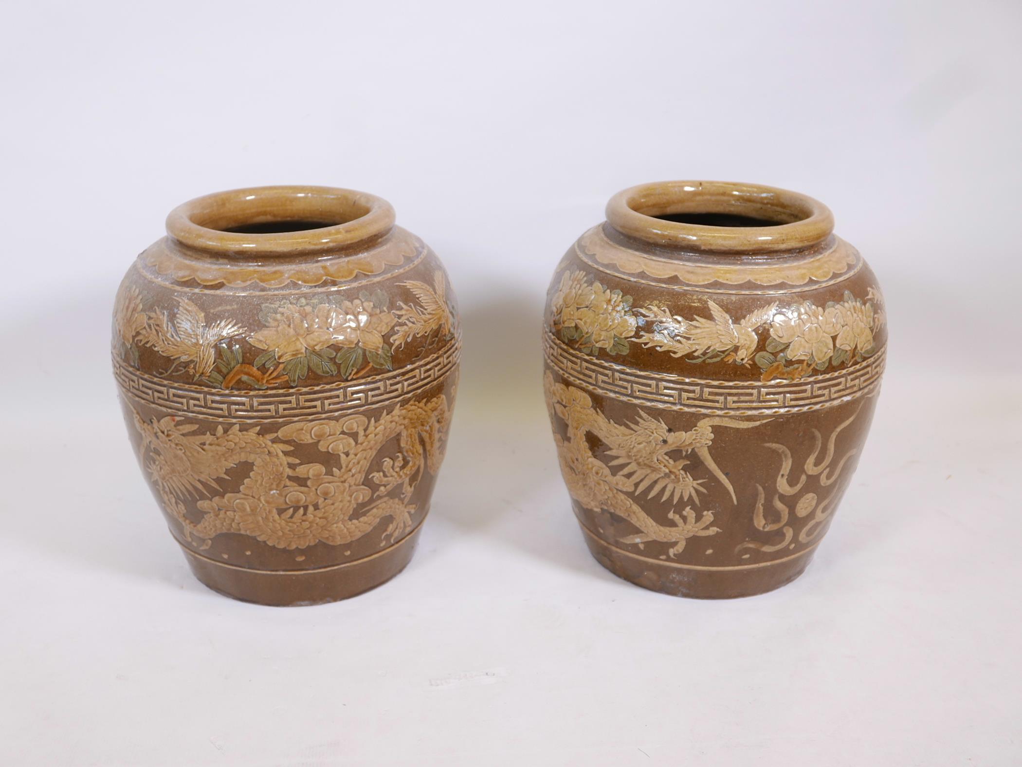 A pair of Chinese earthenware vases with raised dragon decoration, 18" high