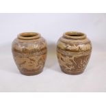 A pair of Chinese earthenware vases with raised dragon decoration, 18" high