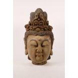 A Chinese carved wood head of Buddha with traces of paint, 16" high