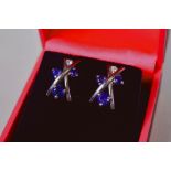 A pair of 9ct white gold, diamond and sapphire crossover earrings