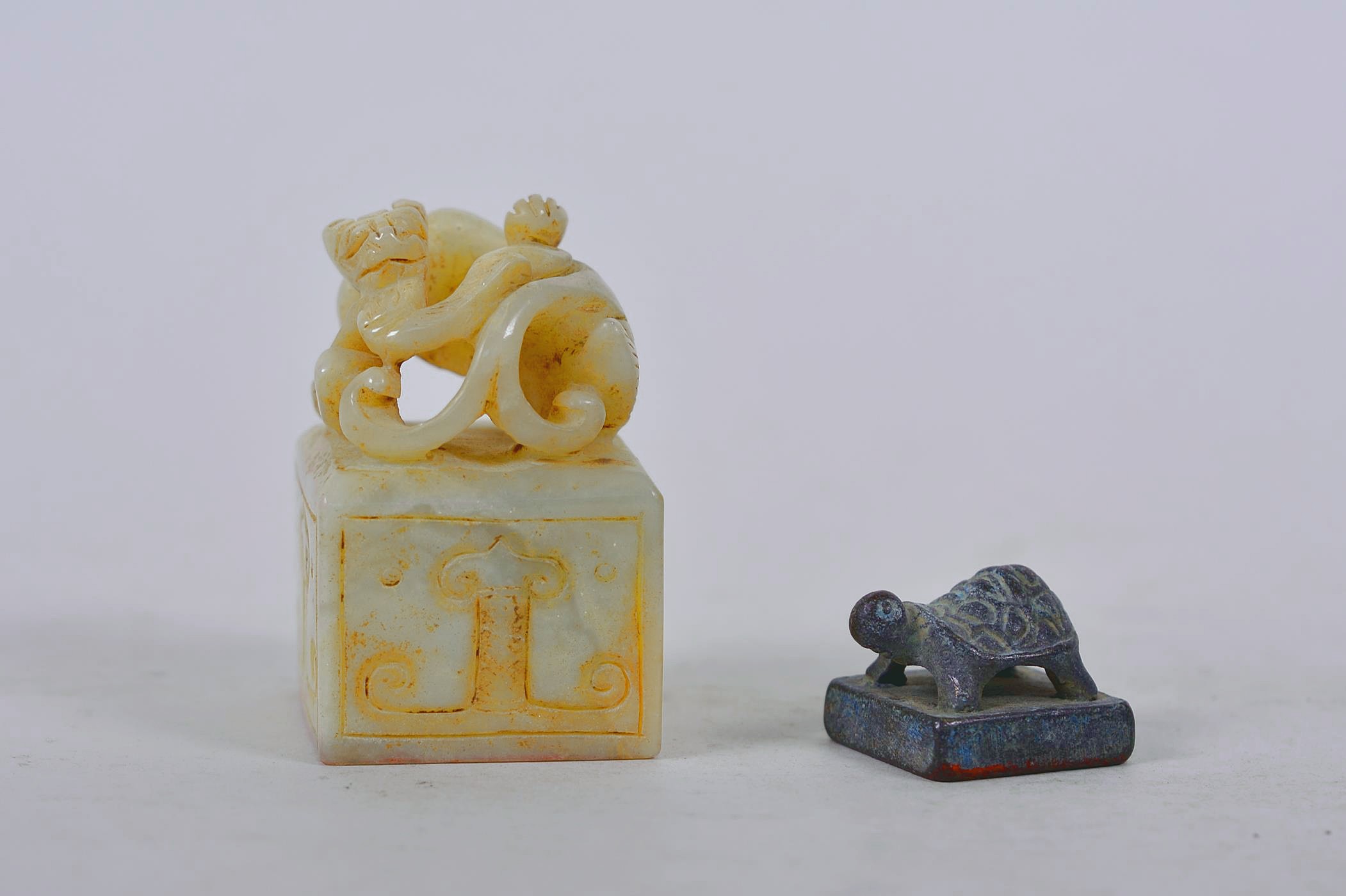 A Chinese carved hardstone seal with kylin decoration, together with a small bronze tortoise seal,