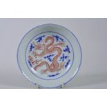 A Chinese blue and white porcelain dish/saucer decorated with a dragon chasing the flaming pearl,