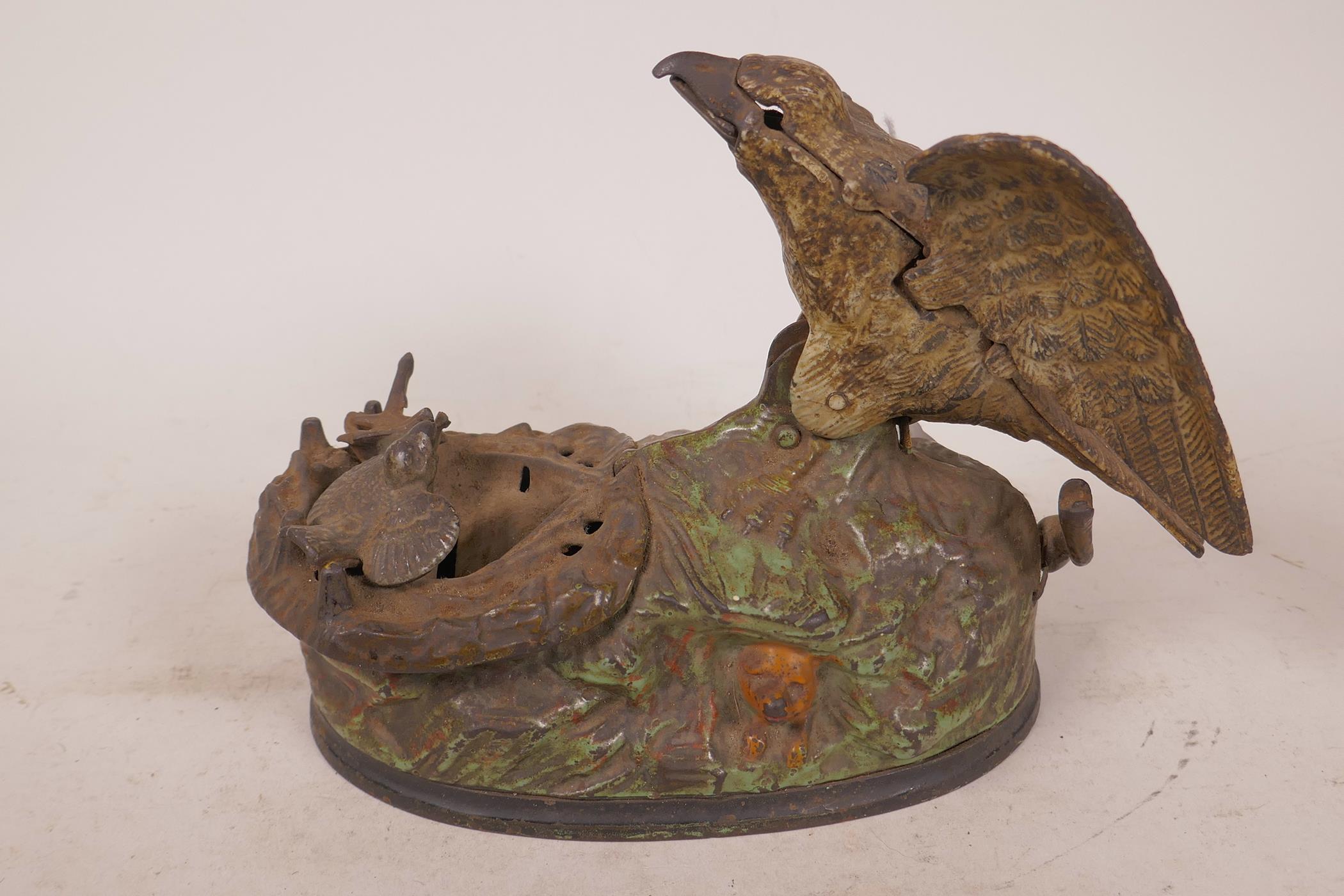 A vintage American cast iron eagle and eaglette mechanical money box with chirp, designed by Charles