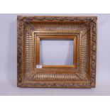 A 'Carvers & Gilders' heavy gilt frame with composition mouldings, A/F, 19" x 21"