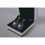 A pair of Art Deco style silver, marcasite and onyx pendant earrings set with central opalite