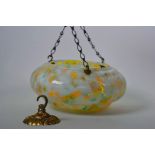 An Art Deco mottled glass hanging lampshade, suspended by three link metal chains, and a brass