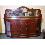 A Victorian mahogany serpentine front sideboard with original mirror back, four doors and barley