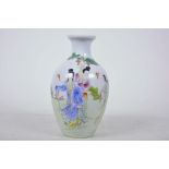 A Chinese porcelain vase decorated with ladies in a garden scene in bright polychrome enamels, 7"