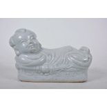 A green glazed Chinese porcelain pillow modelled as a reclining figure, 8" long