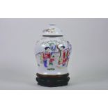 A Chinese Republic ginger jar and cover decorated with women and children in a garden, on a carved