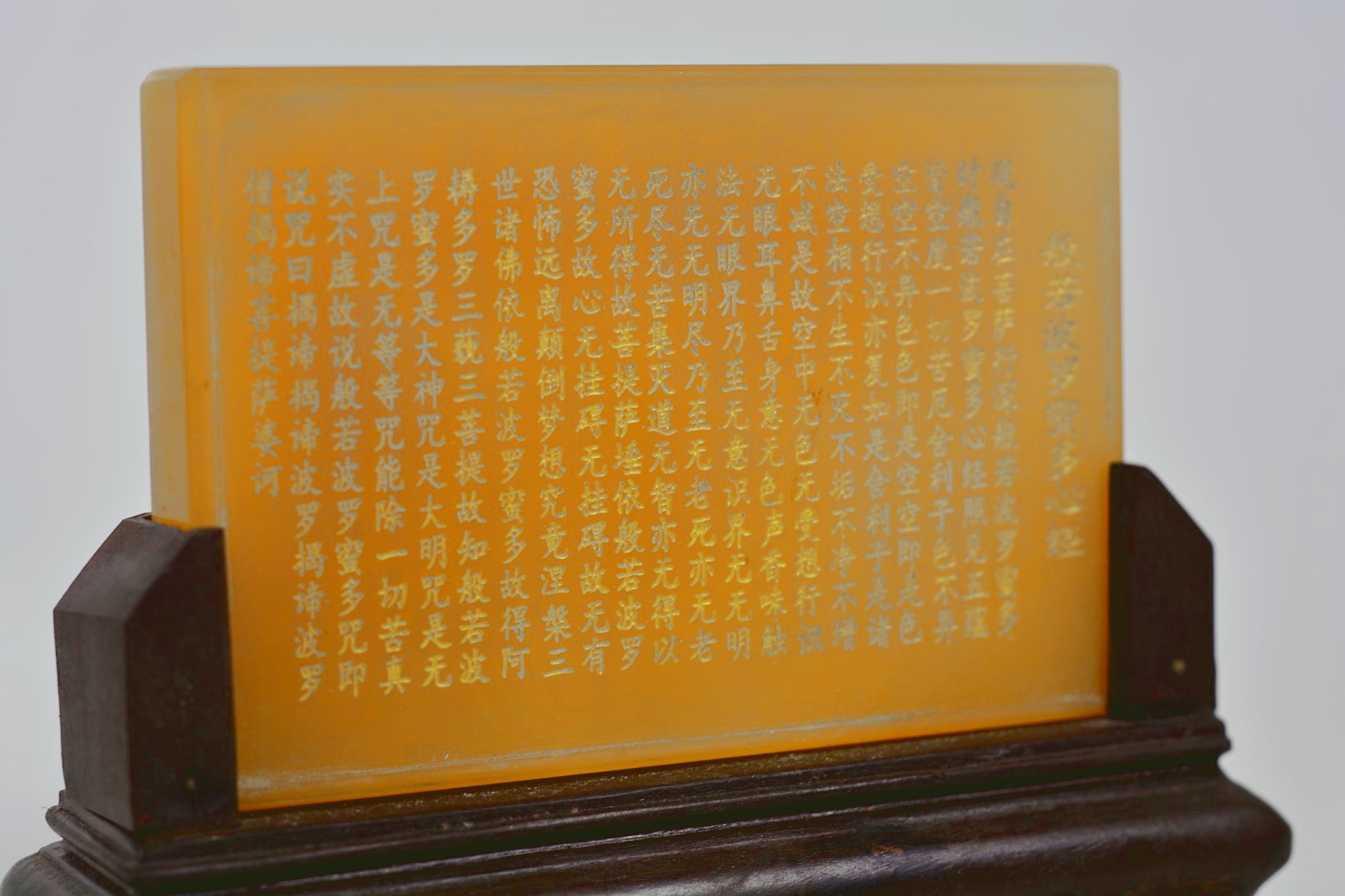 A Chinese amber soapstone tablet with character inscription decoration, mounted on a carved hardwood - Image 4 of 4