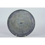 A Chinese circular bronze mirror, the back chased with mythical beasts, 8½" diameter