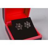 A pair of silver 'spider's web' stud earrings