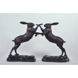 A pair of bronzed metal figures of boxing hares, 11½" high