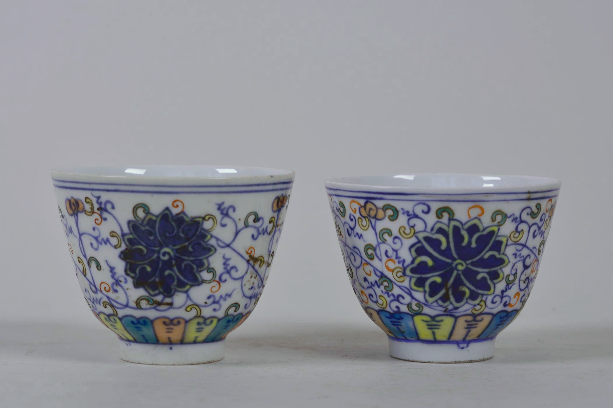A pair of Chinese doucai porcelain tea bowls with lotus flower decoration, 6 character mark to base,