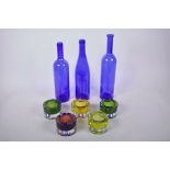 Three 1970s blue glass bottles, largest 13", together with five glass tea light holders