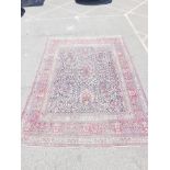 A large Persian carpet with multicolour all over floral decoration on a blue field and red boarders,