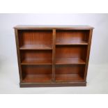 A Edwardian style mahogany open bookcase with reeded side columns on platform base with adjustable