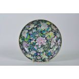 A Chinese famille noire porcelain dish with enamel decoration of Asiatic flowers, 6 character mark