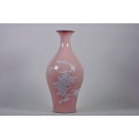 A Chinese pink ground porcelain vase with raised decoration of birds and butterflies amongst