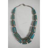 A graduated Indian white metal necklace set with turquoise and coral, 20" long