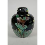 A Chinese black ground Sancai enamelled ginger jar and cover, decorated with brightly painted