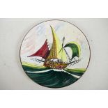 A Continental majolica wall plate painted in bright enamels with an Arab dhow, signed, 12" diameter