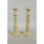 A pair of turned and carved bone candlesticks, 7½" high