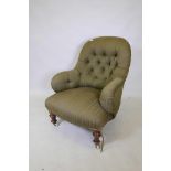 A Victorian button back easy chair, raised on turned supports