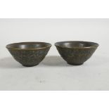 A pair of small Chinese bronze bowls with raised elephant decoration, mark to base, 2½" diameter