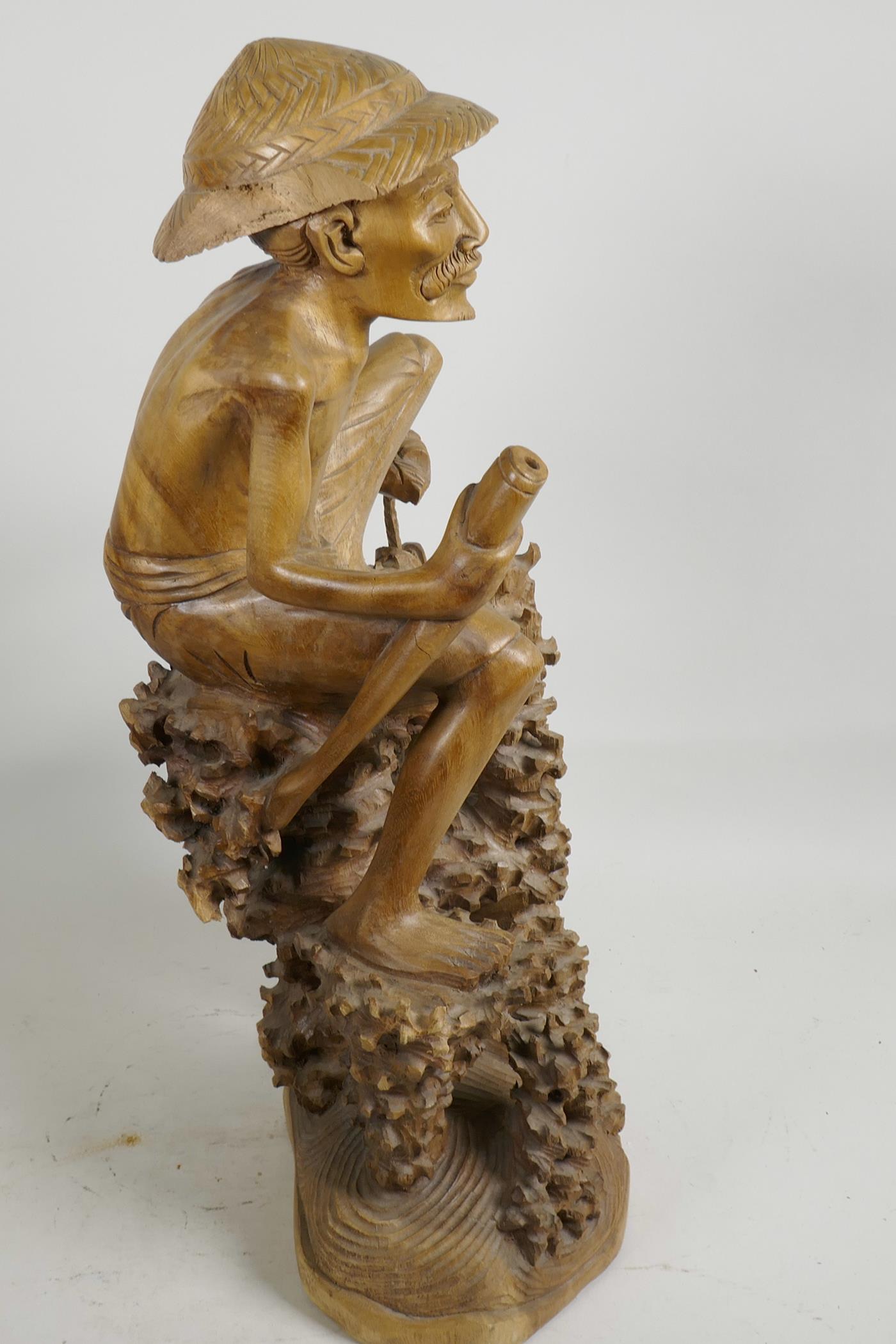 An oriental carved wood figure of a fisherman with large fish, seated on a coral reef, 21" high, A/F - Image 4 of 5