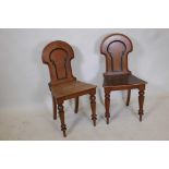 A pair of Victorian mahogany hall chairs with shaped backs and ebonised mouldings, raised on