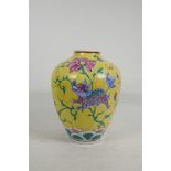 A Chinese yellow glazed porcelain baluster vase decorated with flowers and exotic beasts in bright