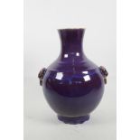 A Chinese purple flambé glazed pottery vase with two mask loop handles, impressed seal mark to base,